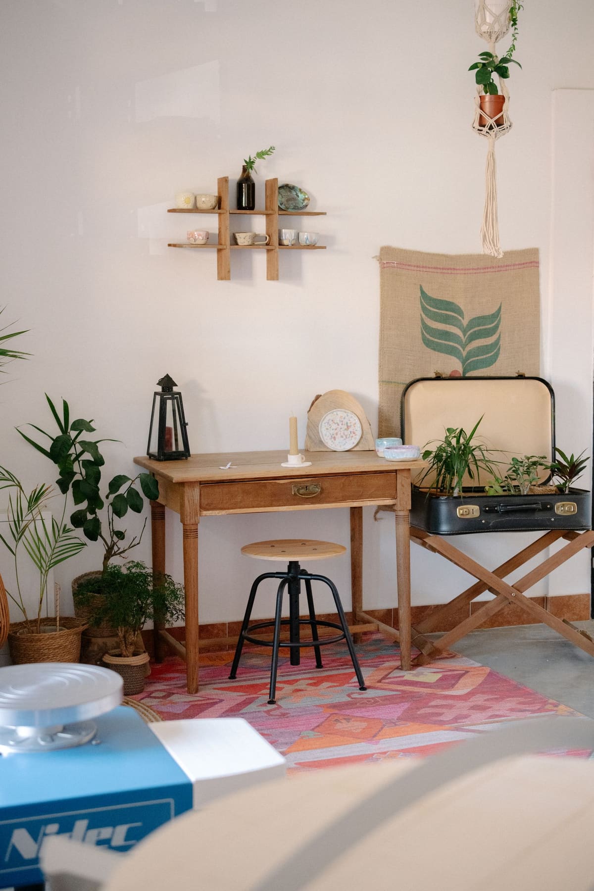 Bureau en bois cosy avec plantes vertes et objets en osier